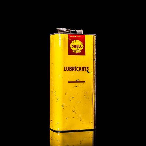 Vintage Shell oil cans with red and yellow branding from the 1900-1920 old logo Vintage Shell oil cans from 1900-19255, featuring the old logo. The photo showcases an antique tin red with yellow accents, displaying the historic Shell emblem. Shot in a studio against a solid black background
