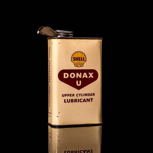 Vintage Shell oil cans with red and yellow branding from the 1900-1920 old logo Vintage Shell oil cans from 1900-19255, featuring the old logo. The photo showcases an antique tin red with yellow accents, displaying the historic Shell emblem. Shot in a studio against a solid black background