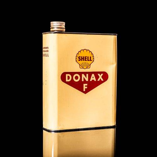 Vintage Shell oil cans with red and yellow branding from the 1900-1920 old logo Vintage Shell oil cans from 1900-19255, featuring the old logo. The photo showcases an antique tin red with yellow accents, displaying the historic Shell emblem. Shot in a studio against a solid black background