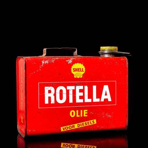 Vintage Shell oil cans with red and yellow branding from the 1900-1920 old logo Vintage Shell oil cans from 1900-19255, featuring the old logo. The photo showcases an antique tin red with yellow accents, displaying the historic Shell emblem. Shot in a studio against a solid black background