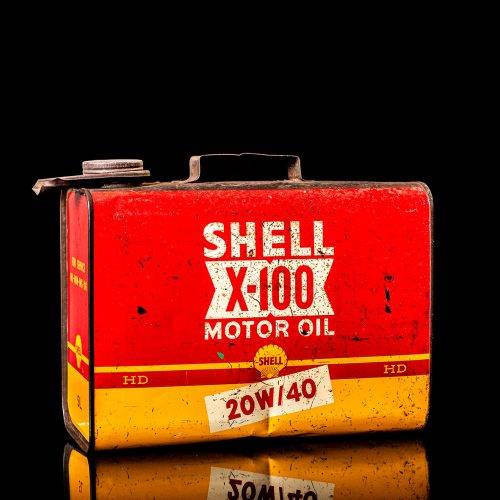 Vintage Shell oil cans with red and yellow branding from the 1900-1920 old logo Vintage Shell oil cans from 1900-19255, featuring the old logo. The photo showcases an antique tin red with yellow accents, displaying the historic Shell emblem. Shot in a studio against a solid black background