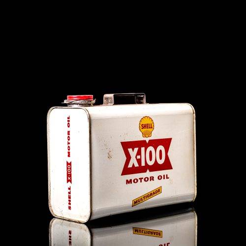 Vintage Shell oil can from 1950–1960 with white base color, yellow and red accents, and the classic Shell logo. Antique motor oil tin displayed in a studio setting against a solid black background."