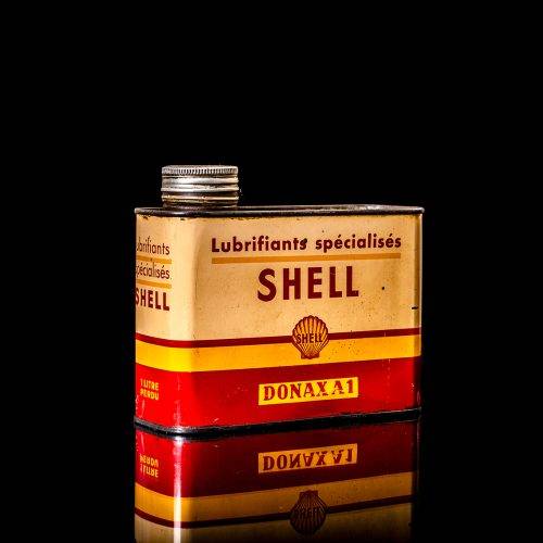 Vintage Shell oil cans with red and yellow branding from the 1900-1920 old logo Vintage Shell oil cans from 1900-19255, featuring the old logo. The photo showcases an antique tin red with yellow accents, displaying the historic Shell emblem. Shot in a studio against a solid black background