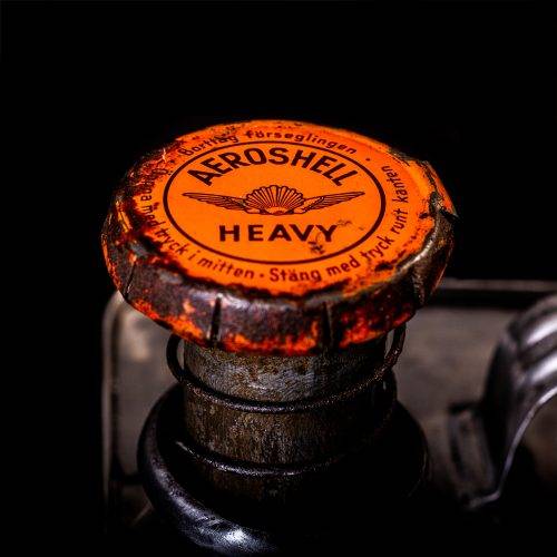 Vintage Shell oil cans with red and yellow branding from the 1900-1920 old logo Vintage Shell oil cans from 1900-19255, featuring the old logo. The photo showcases an antique tin red with yellow accents, displaying the historic Shell emblem. Shot in a studio against a solid black background
