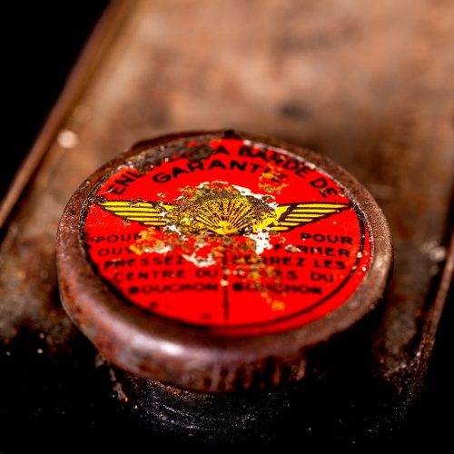 Vintage Shell oil cans with red and yellow branding from the 1900-1920 old logo Vintage Shell oil cans from 1900-19255, featuring the old logo. The photo showcases an antique tin red with yellow accents, displaying the historic Shell emblem. Shot in a studio against a solid black background