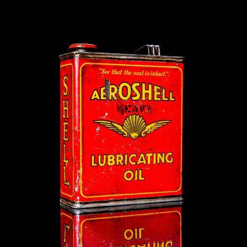 Vintage Shell oil cans with red and yellow branding from the 1900-1920 old logo Vintage Shell oil cans from 1900-19255, featuring the old logo. The photo showcases an antique tin red with yellow accents, displaying the historic Shell emblem. Shot in a studio against a solid black background