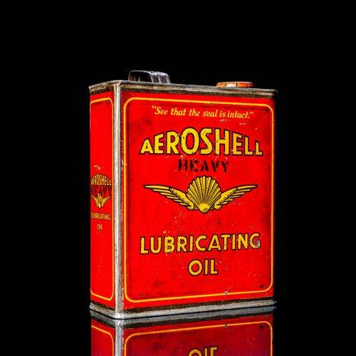 Vintage Shell oil cans with red and yellow branding from the 1900-1920 old logo Vintage Shell oil cans from 1900-19255, featuring the old logo. The photo showcases an antique tin red with yellow accents, displaying the historic Shell emblem. Shot in a studio against a solid black background