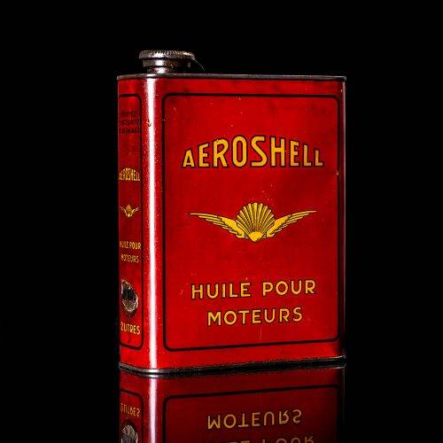 Vintage Shell oil cans with red and yellow branding from the 1900-1920 old logo Vintage Shell oil cans from 1900-19255, featuring the old logo. The photo showcases an antique tin red with yellow accents, displaying the historic Shell emblem. Shot in a studio against a solid black background