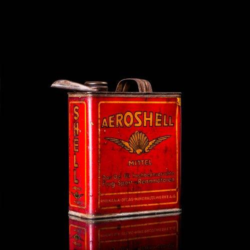 Vintage Shell oil cans with red and yellow branding from the 1900-1920 old logo Vintage Shell oil cans from 1900-19255, featuring the old logo. The photo showcases an antique tin red with yellow accents, displaying the historic Shell emblem. Shot in a studio against a solid black background