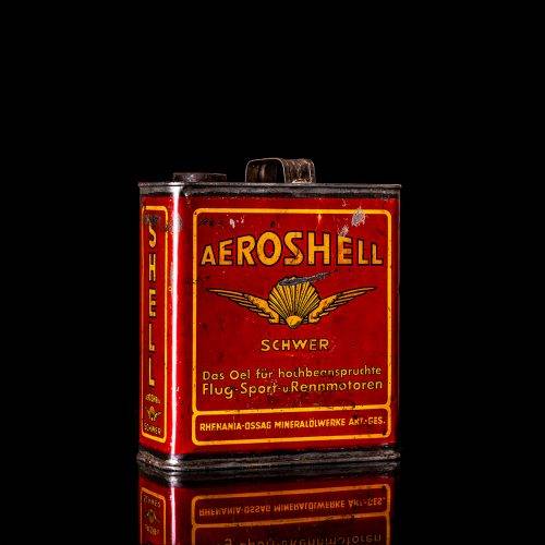 Vintage Shell oil cans with red and yellow branding from the 1900-1920 old logo Vintage Shell oil cans from 1900-19255, featuring the old logo. The photo showcases an antique tin red with yellow accents, displaying the historic Shell emblem. Shot in a studio against a solid black background