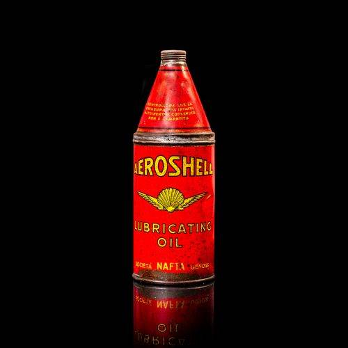 Rare and unique vintage Aeroshell oil can from 1900–1950 with red base and yellow accents, featuring the aeroShell logo. This antique motor oil tin is displayed in a studio setting against a solid black background.