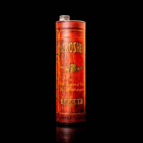 Rare and unique vintage Aeroshell oil can from 1900–1950 with red base and yellow accents, featuring the aeroShell logo. This antique motor oil tin is displayed in a studio setting against a solid black background.