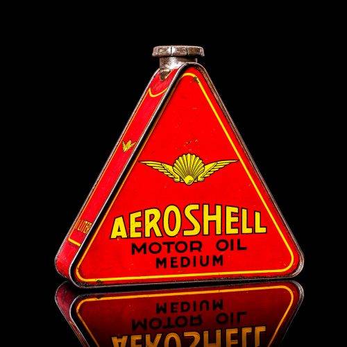 Rare and unique vintage Aeroshell oil can from 1900–1950 with red base and yellow accents, featuring the aeroShell logo. This antique motor oil tin is displayed in a studio setting against a solid black background.