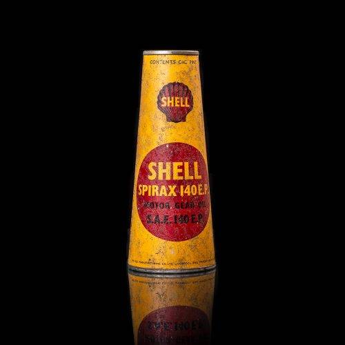 Rare and unique vintage conical shell oil can from 1900–1950 with a red base and yellow accents, featuring the classic shell logo. This antique, cone-shaped motor oil tin is showcased in a studio setting against a solid black background.