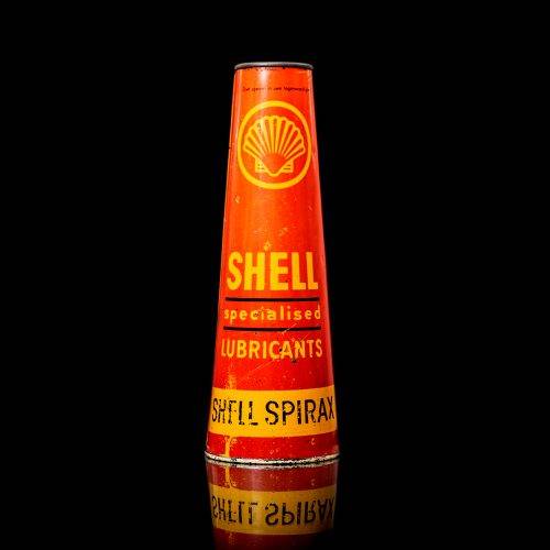 Vintage Shell oil cans with red and yellow branding from the 1900-1920 old logo Vintage Shell oil cans from 1900-19255, featuring the old logo. The photo showcases an antique tin red with yellow accents, displaying the historic Shell emblem. Shot in a studio against a solid black background
