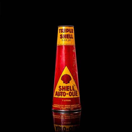 Rare and unique vintage conical shell oil can from 1900–1950 with a red base and yellow accents, featuring the classic shell logo. This antique, cone-shaped motor oil tin is showcased in a studio setting against a solid black background.
