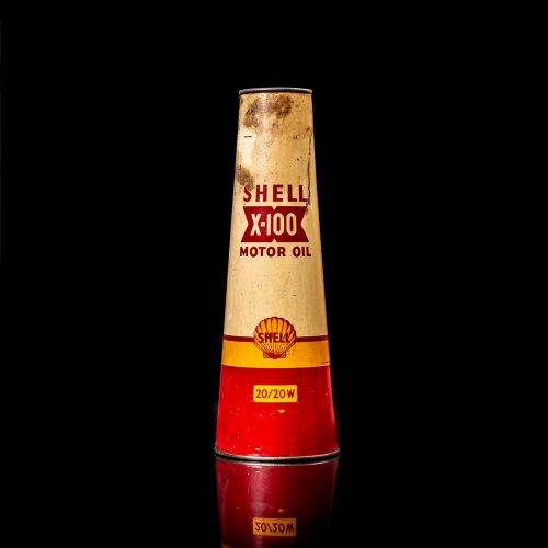 Rare and unique vintage conical shell oil can from 1900–1950 with a red base and yellow accents, featuring the classic shell logo. This antique, cone-shaped motor oil tin is showcased in a studio setting against a solid black background.