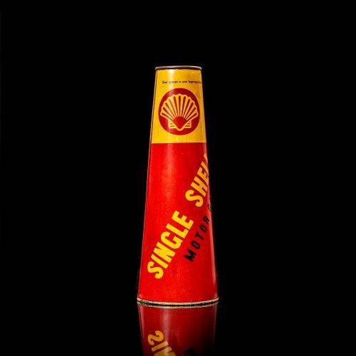 Vintage Shell oil cans with red and yellow branding from the 1900-1920 old logo Vintage Shell oil cans from 1900-19255, featuring the old logo. The photo showcases an antique tin red with yellow accents, displaying the historic Shell emblem. Shot in a studio against a solid black background