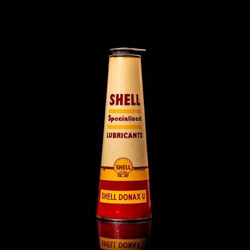 Rare and unique vintage conical shell oil can from 1900–1950 with a red base and yellow accents, featuring the classic shell logo. This antique, cone-shaped motor oil tin is showcased in a studio setting against a solid black background."