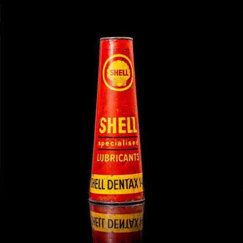 Vintage Shell oil cans with red and yellow branding from the 1900-1920 old logo Vintage Shell oil cans from 1900-19255, featuring the old logo. The photo showcases an antique tin red with yellow accents, displaying the historic Shell emblem. Shot in a studio against a solid black background