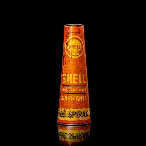 Rare and unique vintage conical shell oil can from 1900–1950 with a red base and yellow accents, featuring the classic shell logo. This antique, cone-shaped motor oil tin is showcased in a studio setting against a solid black background."