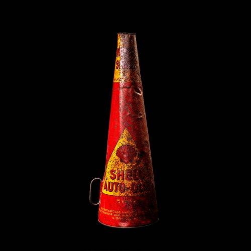Rare and unique vintage conical shell oil can from 1900–1950 with a red base and yellow accents, featuring the classic shell logo. This antique, cone-shaped motor oil tin is showcased in a studio setting against a solid black background."