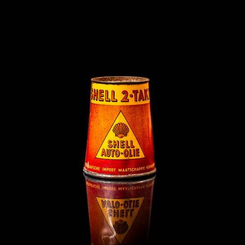 Vintage Shell oil cans with red and yellow branding from the 1900-1920 old logo Vintage Shell oil cans from 1900-19255, featuring the old logo. The photo showcases an antique tin red with yellow accents, displaying the historic Shell emblem. Shot in a studio against a solid black background