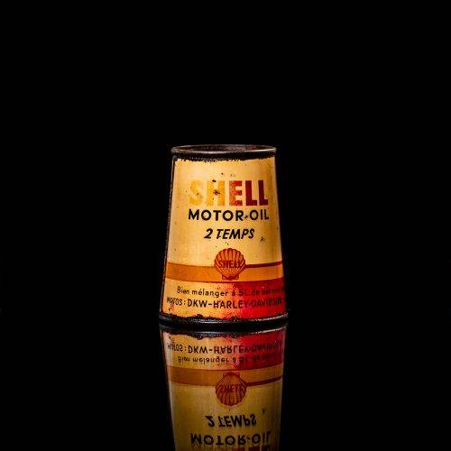 Vintage Shell oil cans with red and yellow branding from the 1900-1920 old logo Vintage Shell oil cans from 1900-19255, featuring the old logo. The photo showcases an antique tin red with yellow accents, displaying the historic Shell emblem. Shot in a studio against a solid black background
