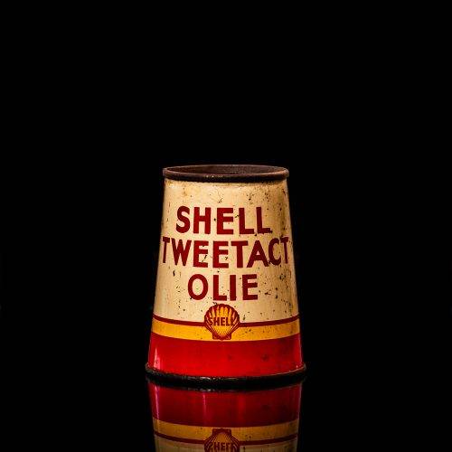 Vintage Shell oil cans with red and yellow branding from the 1900-1920 old logo Vintage Shell oil cans from 1900-19255, featuring the old logo. The photo showcases an antique tin red with yellow accents, displaying the historic Shell emblem. Shot in a studio against a solid black background
