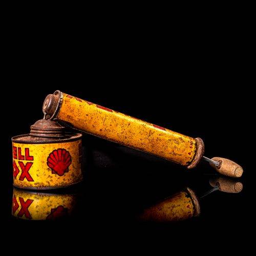 Vintage Shell oil cans with red and yellow branding from the 1900-1920 old logo Vintage Shell oil cans from 1900-19255, featuring the old logo. The photo showcases an antique tin red with yellow accents, displaying the historic Shell emblem. Shot in a studio against a solid black background