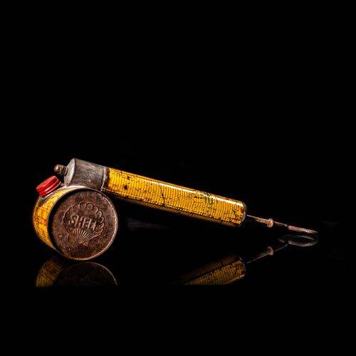Rare and unique vintage Shell flitgun from 1900–1950 with a red base and yellow accents, featuring the classic Shell logo. This antique insect spray canister is displayed in a studio setting against a solid black background