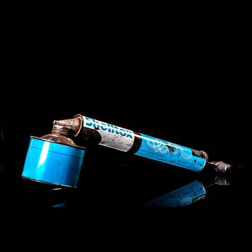 Vintage Shell oil cans with red and yellow branding from the 1900-1920 old logo Vintage Shell oil cans from 1900-19255, featuring the old logo. The photo showcases an antique tin red with yellow accents, displaying the historic Shell emblem. Shot in a studio against a solid black background