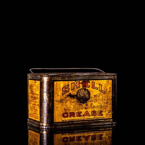 Vintage Shell oil cans with red and yellow branding from the 1900-1920 old logo Vintage Shell oil cans from 1900-19255, featuring the old logo. The photo showcases an antique tin red with yellow accents, displaying the historic Shell emblem. Shot in a studio against a solid black background
