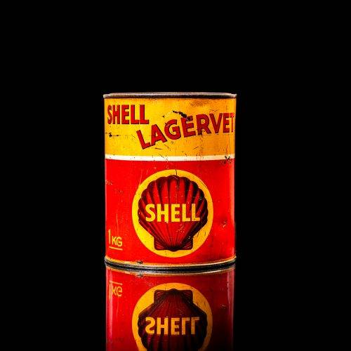 Vintage Shell oil cans with red and yellow branding from the 1900-1920 old logo Vintage Shell oil cans from 1900-19255, featuring the old logo. The photo showcases an antique tin red with yellow accents, displaying the historic Shell emblem. Shot in a studio against a solid black background
