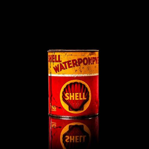 Vintage Shell oil cans with red and yellow branding from the 1900-1920 old logo Vintage Shell oil cans from 1900-19255, featuring the old logo. The photo showcases an antique tin red with yellow accents, displaying the historic Shell emblem. Shot in a studio against a solid black background