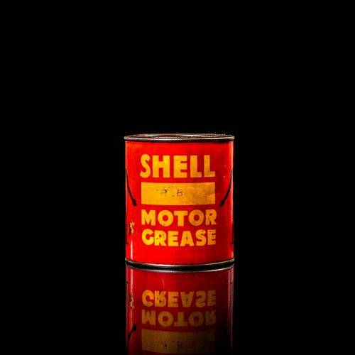 Vintage Shell oil cans with red and yellow branding from the 1900-1920 old logo Vintage Shell oil cans from 1900-19255, featuring the old logo. The photo showcases an antique tin red with yellow accents, displaying the historic Shell emblem. Shot in a studio against a solid black background