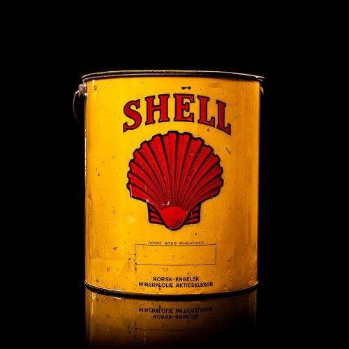 Vintage Shell oil cans with red and yellow branding from the 1900-1920 old logo Vintage Shell oil cans from 1900-19255, featuring the old logo. The photo showcases an antique tin red with yellow accents, displaying the historic Shell emblem. Shot in a studio against a solid black background
