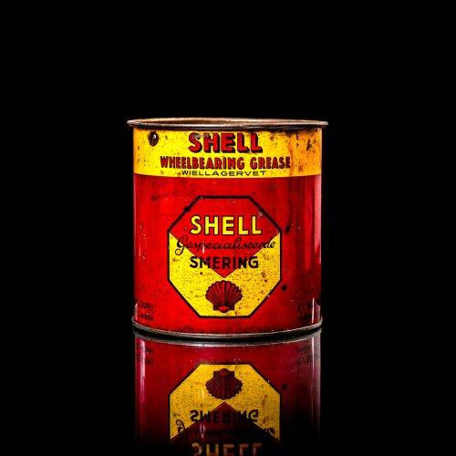 Vintage Shell oil cans with red and yellow branding from the 1900-1920 old logo Vintage Shell oil cans from 1900-19255, featuring the old logo. The photo showcases an antique tin red with yellow accents, displaying the historic Shell emblem. Shot in a studio against a solid black background