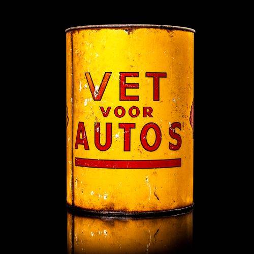 Rare and unique vintage Shell grease can from 1900–1950 with a red base and yellow detailing, featuring the classic Shell logo. This antique lubricant tin is displayed in a studio setting against a solid black background.