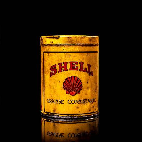 Vintage Shell oil cans with red and yellow branding from the 1900-1920 old logo Vintage Shell oil cans from 1900-19255, featuring the old logo. The photo showcases an antique tin red with yellow accents, displaying the historic Shell emblem. Shot in a studio against a solid black background