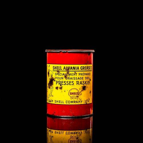Vintage Shell oil cans with red and yellow branding from the 1900-1920 old logo Vintage Shell oil cans from 1900-19255, featuring the old logo. The photo showcases an antique tin red with yellow accents, displaying the historic Shell emblem. Shot in a studio against a solid black background