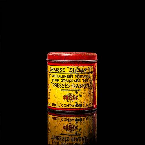 Vintage Shell oil cans with red and yellow branding from the 1900-1920 old logo Vintage Shell oil cans from 1900-19255, featuring the old logo. The photo showcases an antique tin red with yellow accents, displaying the historic Shell emblem. Shot in a studio against a solid black background