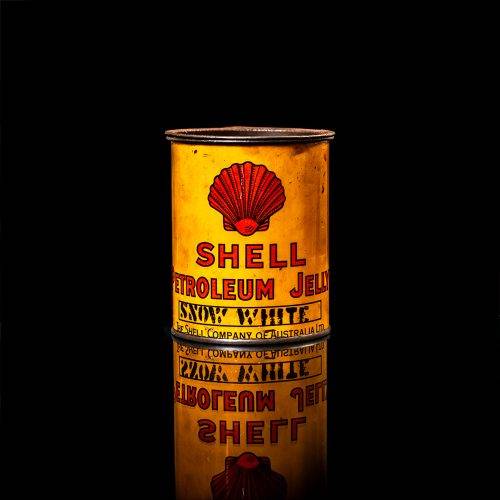 Rare and unique vintage Shell grease can from 1900–1950 with a red base and yellow detailing, featuring the classic Shell logo. This antique lubricant tin is displayed in a studio setting against a solid black background."