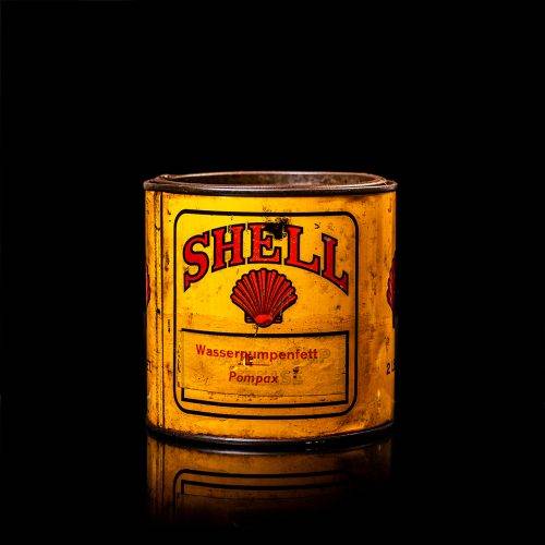 Vintage Shell oil cans with red and yellow branding from the 1900-1920 old logo Vintage Shell oil cans from 1900-19255, featuring the old logo. The photo showcases an antique tin red with yellow accents, displaying the historic Shell emblem. Shot in a studio against a solid black background