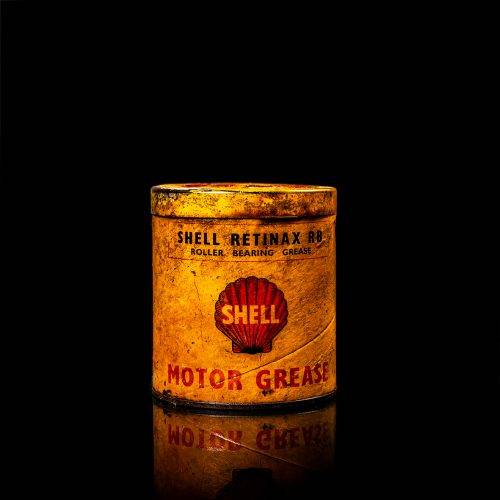 Vintage Shell oil cans with red and yellow branding from the 1900-1920 old logo Vintage Shell oil cans from 1900-19255, featuring the old logo. The photo showcases an antique tin red with yellow accents, displaying the historic Shell emblem. Shot in a studio against a solid black background