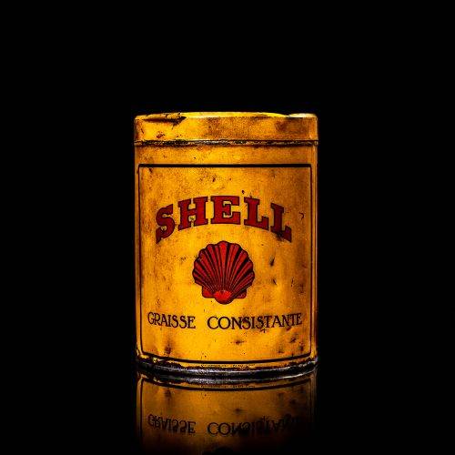 Vintage Shell oil cans with red and yellow branding from the 1900-1920 old logo Vintage Shell oil cans from 1900-19255, featuring the old logo. The photo showcases an antique tin red with yellow accents, displaying the historic Shell emblem. Shot in a studio against a solid black background