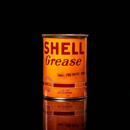 Vintage Shell oil cans with red and yellow branding from the 1900-1920 old logo Vintage Shell oil cans from 1900-19255, featuring the old logo. The photo showcases an antique tin red with yellow accents, displaying the historic Shell emblem. Shot in a studio against a solid black background