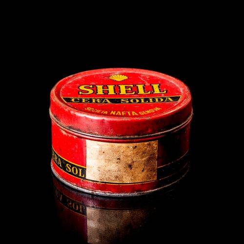 Vintage Shell oil cans with red and yellow branding from the 1900-1920 old logo Vintage Shell oil cans from 1900-19255, featuring the old logo. The photo showcases an antique tin red with yellow accents, displaying the historic Shell emblem. Shot in a studio against a solid black background