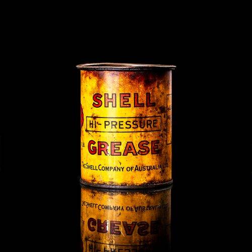 Vintage Shell oil cans with red and yellow branding from the 1900-1920 old logo Vintage Shell oil cans from 1900-19255, featuring the old logo. The photo showcases an antique tin red with yellow accents, displaying the historic Shell emblem. Shot in a studio against a solid black background