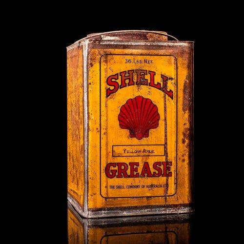 Vintage Shell oil cans with red and yellow branding from the 1900-1920 old logo Vintage Shell oil cans from 1900-19255, featuring the old logo. The photo showcases an antique tin red with yellow accents, displaying the historic Shell emblem. Shot in a studio against a solid black background